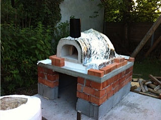 Auf die Grundplatte 10 cm stark aus normalem Beton wird eine 11cm Promatplatte gelegt und darauf der Ofeneinsatz