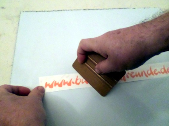 Mit einem Plasterakel noch einmal die Übertragungsfolie fest auf die Folie und das Trägerpapier drücken.